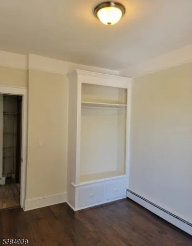 an empty room with wooden floor and closet