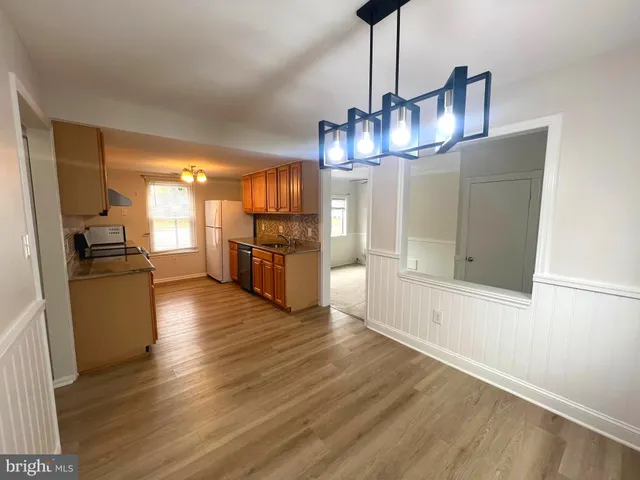 a view of a kitchen with a sink wooden floor and a refrigerator