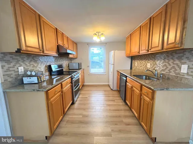 a kitchen with stainless steel appliances granite countertop wooden cabinets a sink and dishwasher