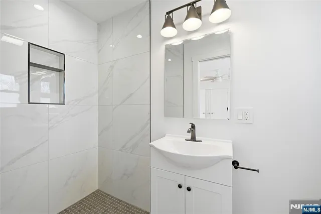 a bathroom with a sink a mirror and a shower