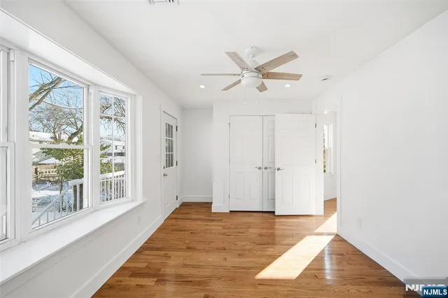 a view of a big room with wooden floor and windows