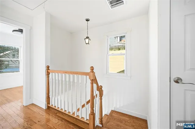 a view of empty room with wooden floor and window