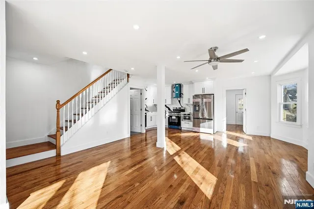 a view of a livingroom with wooden floor and staircase