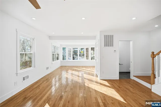 a view of empty room with wooden floor and window