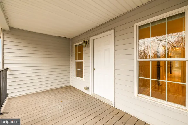 a view of a balcony with wooden floor and a window