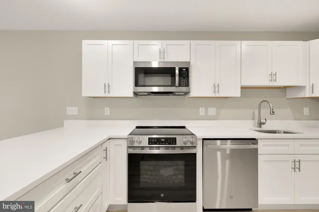 a kitchen with white cabinets and stainless steel appliances