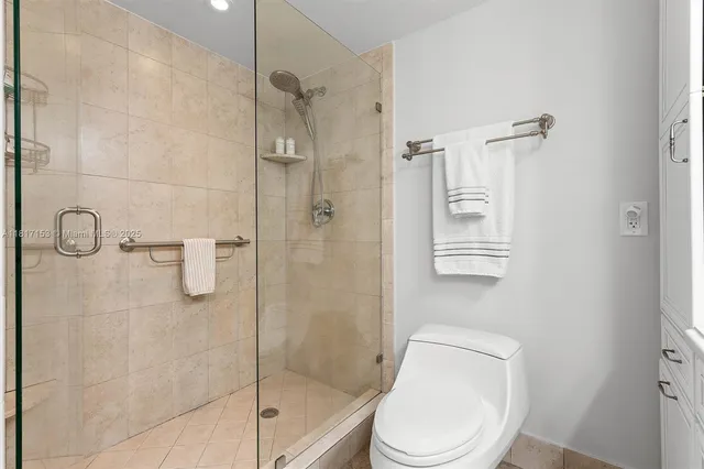 a white toilet next to a bathroom