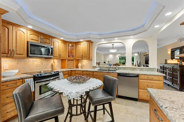 a kitchen with a table chairs microwave and stove top oven