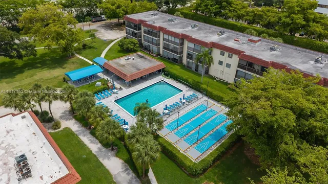 an aerial view of a tennis ground with a large pool