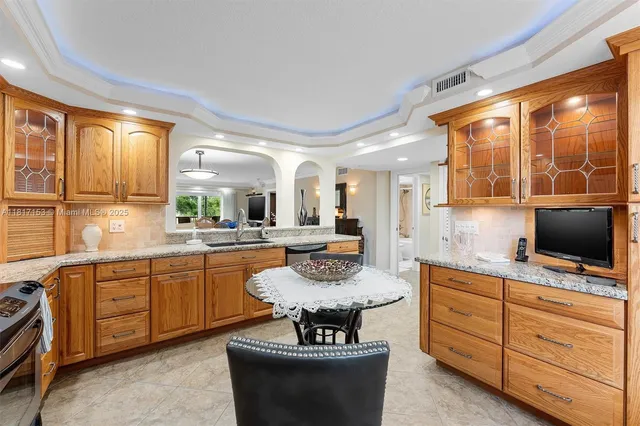 a kitchen with granite countertop a stove and white cabinets