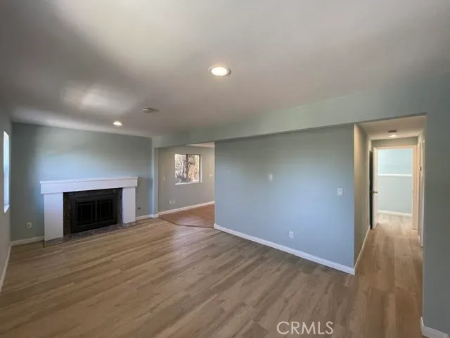 a view of an empty room with window and fire place