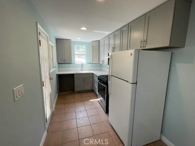 a kitchen with a refrigerator sink stove and cabinets
