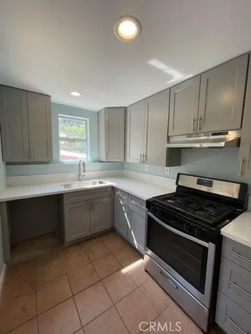 a kitchen with a sink stove top oven and cabinets