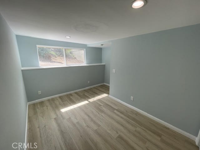 6818 Santa Susana Pass Road Simi Valley, CA 93063 - Photo 7 of 12 an empty room with wooden floor and windows