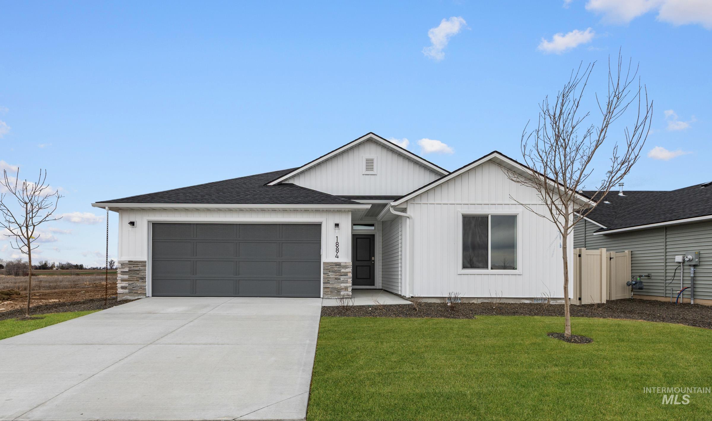 1884 West Unforgettable Street Meridian, ID 83642 - Photo 1 of 1 View of front facade with an attached garage, concrete driveway, roof with shingles, board and batten siding, and stone siding