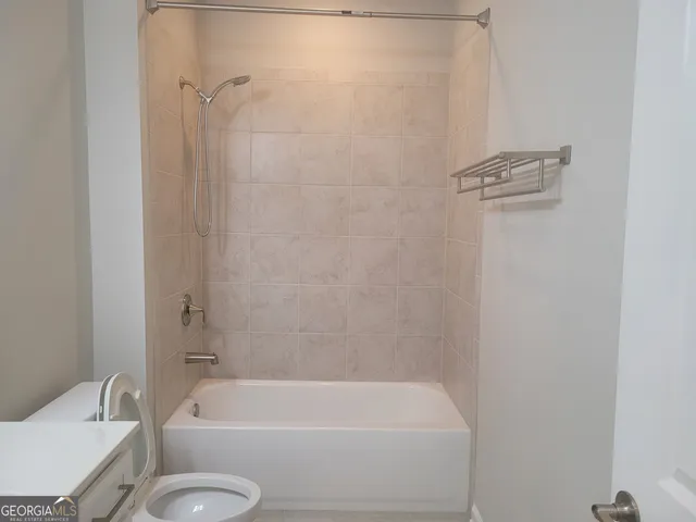 a bathroom with a toilet and a bath tub