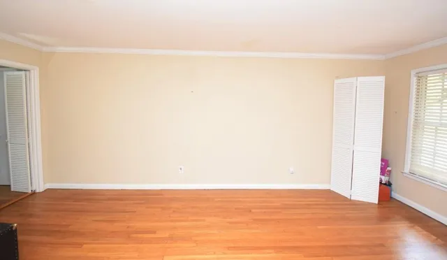 a bed sitting in a bedroom next to a window