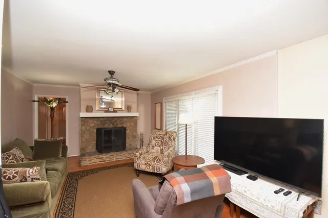 a living room with furniture a fireplace and a flat screen tv