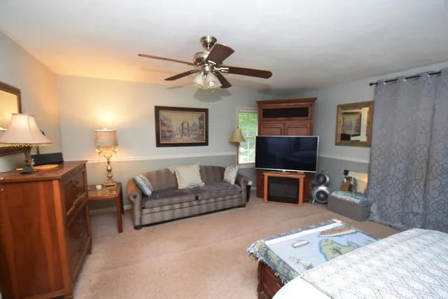 a living room with furniture a flat screen tv and a lamp