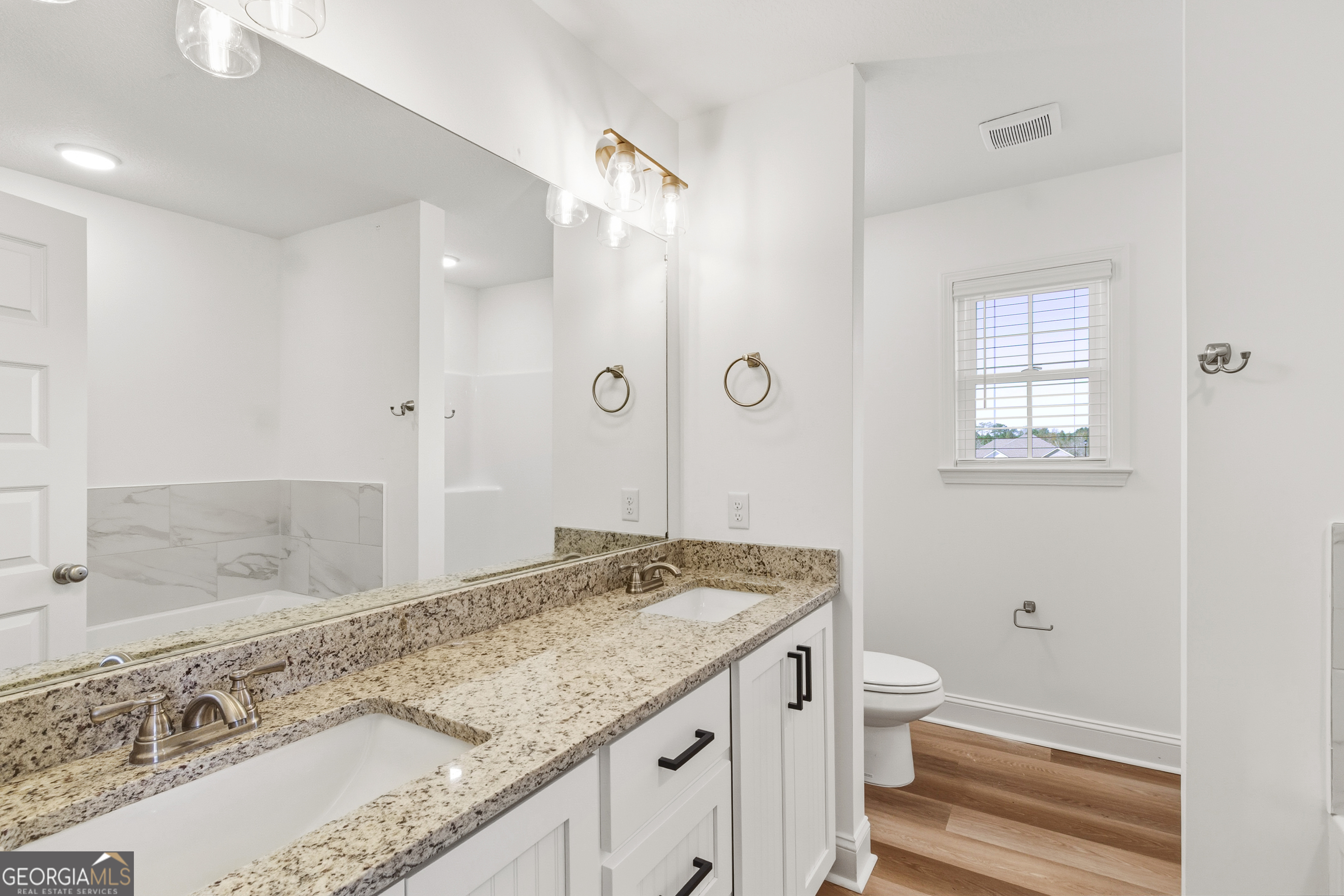 477 Jack Kennedy Road Statesboro, GA 30458 - Photo 17 of 32 a bathroom with a granite countertop sink a toilet and shower