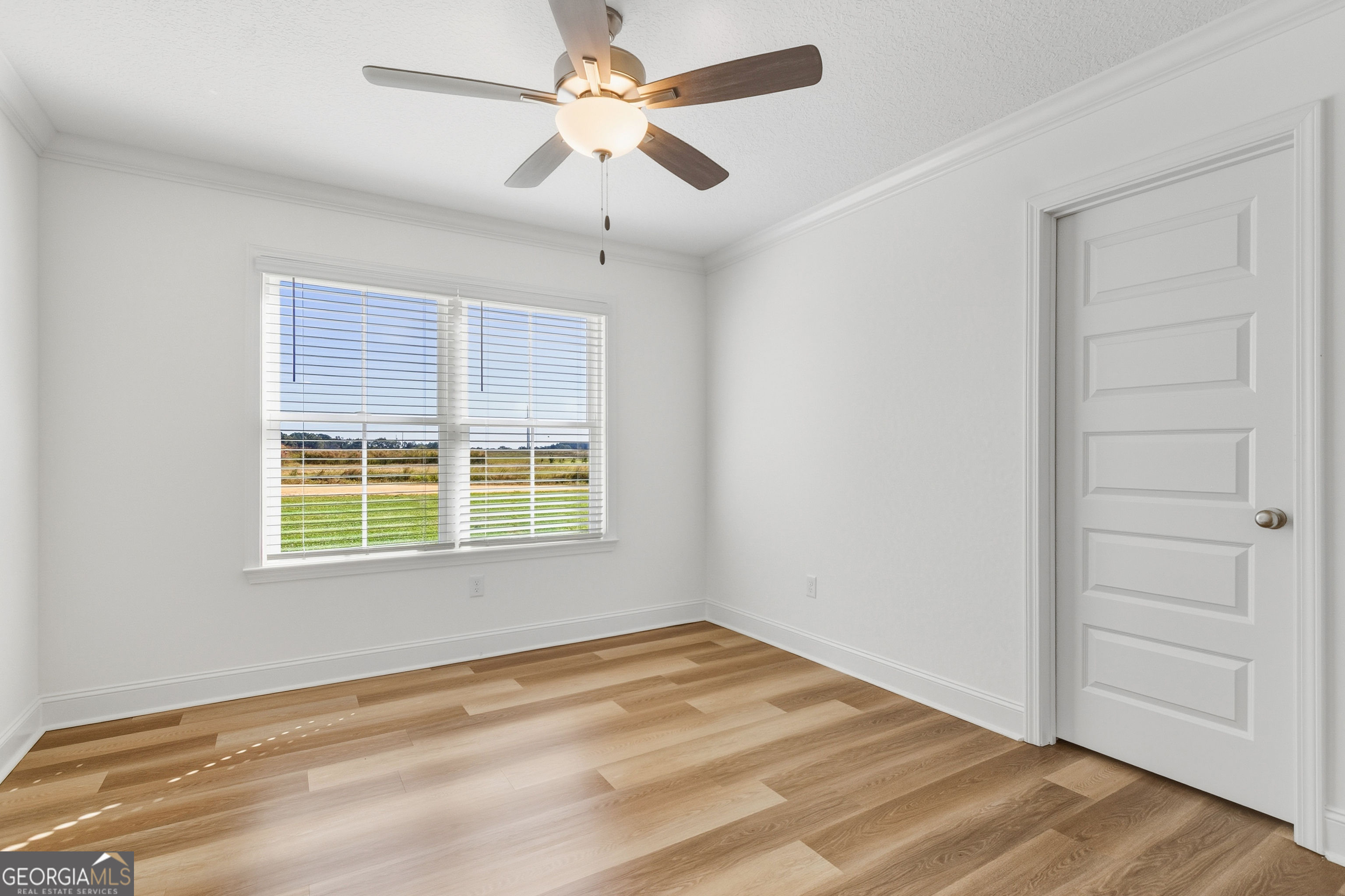 477 Jack Kennedy Road Statesboro, GA 30458 - Photo 19 of 32 a view of an empty room with a window and wooden floor