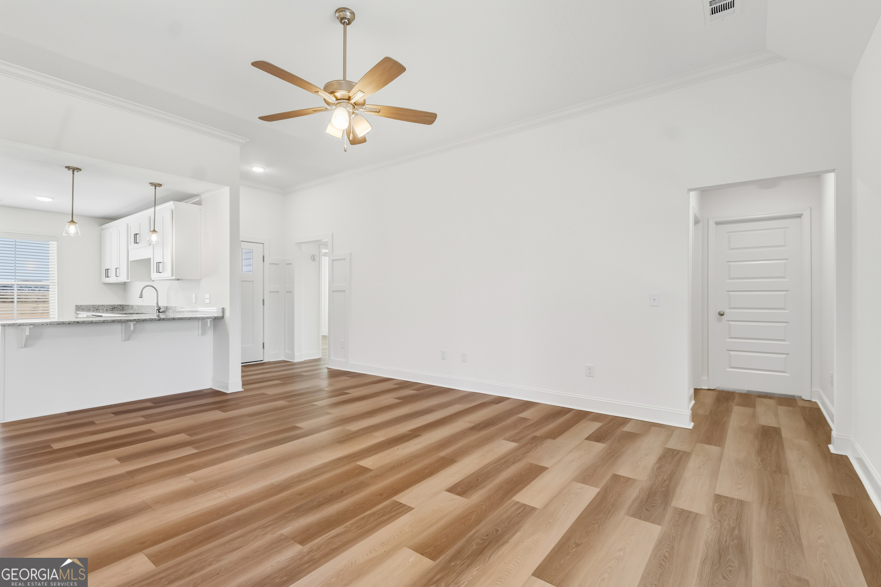 477 Jack Kennedy Road Statesboro, GA 30458 - Photo 6 of 32 a view of kitchen and empty room with wooden floor