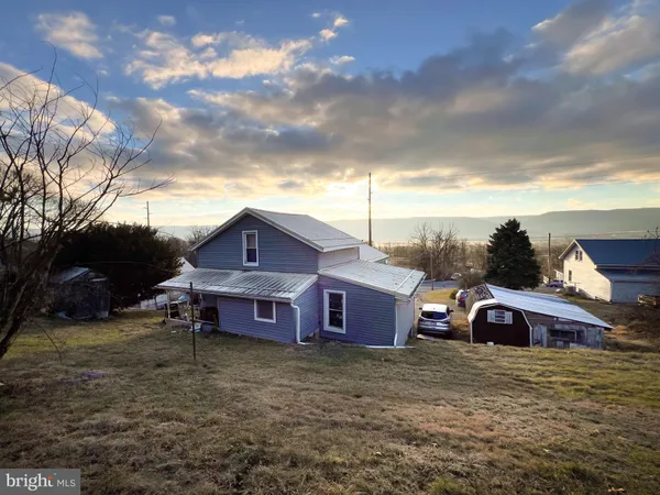 a view of a big house with a big yard and a large tree