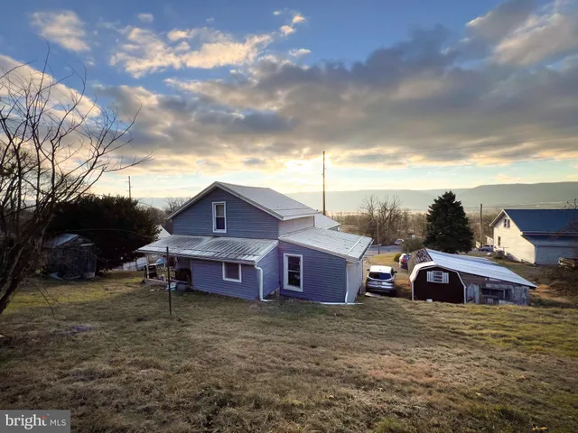 a view of a big house with a big yard and a large tree