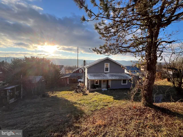 a view of a big house with a big yard and large tree
