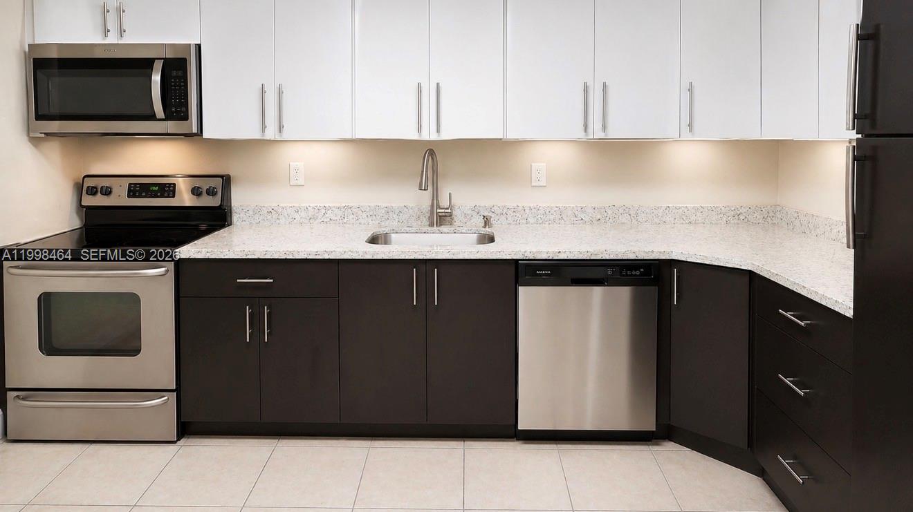 880 East 26th Street Hialeah, FL 33013 - Photo 6 of 34 a kitchen with stainless steel appliances granite countertop a sink stove and microwave