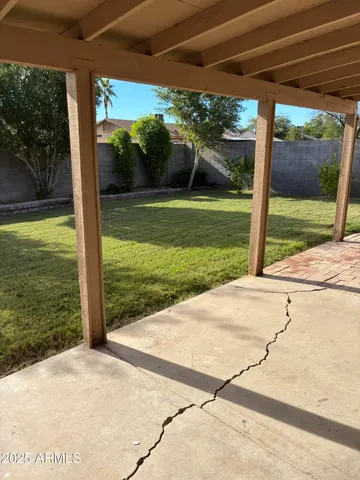 a view of a patio with a table and chairs under an umbrella