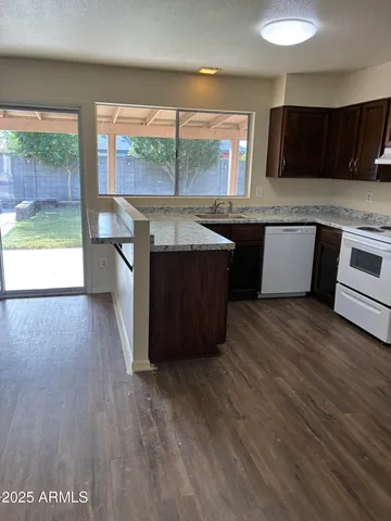 a kitchen with a wooden floor and a large window