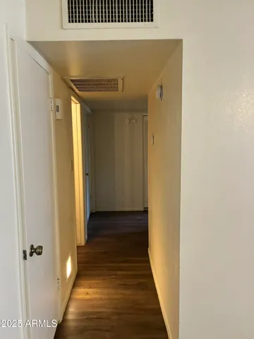 a view of a hallway with wooden floor