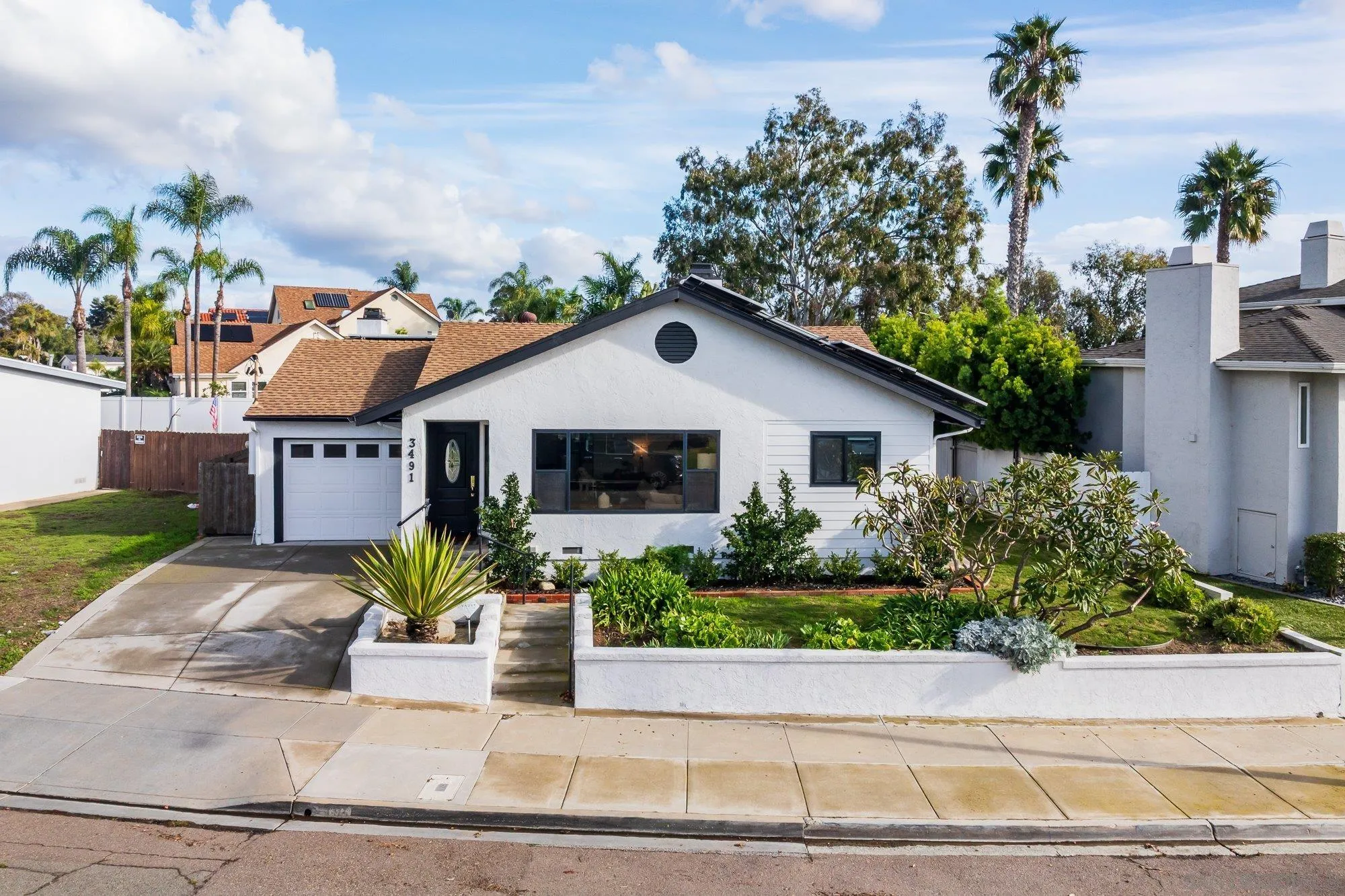 3491 Shawnee Road San Diego, CA 92117 - Photo 1 of 66 a front view of a house with a yard and a garden