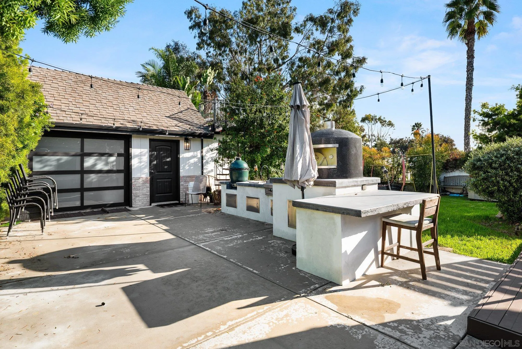 3491 Shawnee Road San Diego, CA 92117 - Photo 44 of 66 a view of a patio with table and chairs potted plants and a large tree
