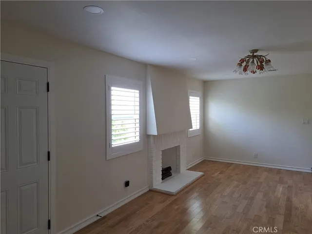 a view of a room with wooden floor and windows in it
