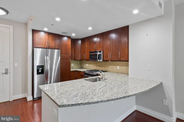 a kitchen with kitchen island a sink and refrigerator
