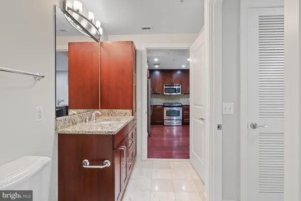 a bathroom with a granite countertop sink and washing machine