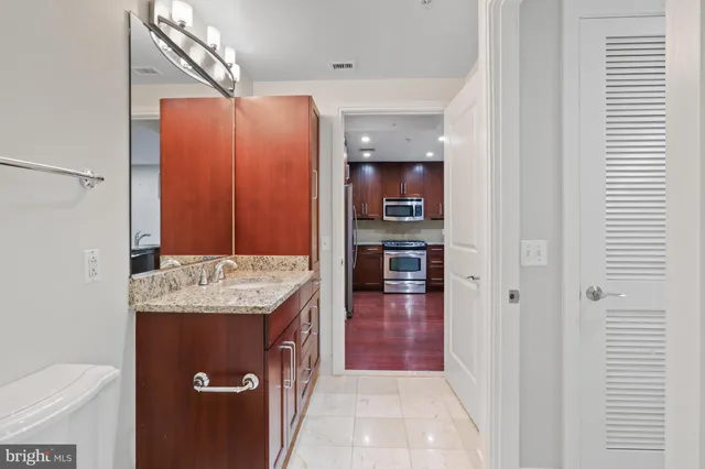 a bathroom with a granite countertop sink and washing machine