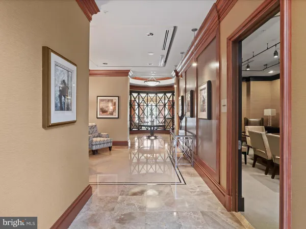 a dining hall with stainless steel appliances granite countertop a dining table chairs and a chandelier