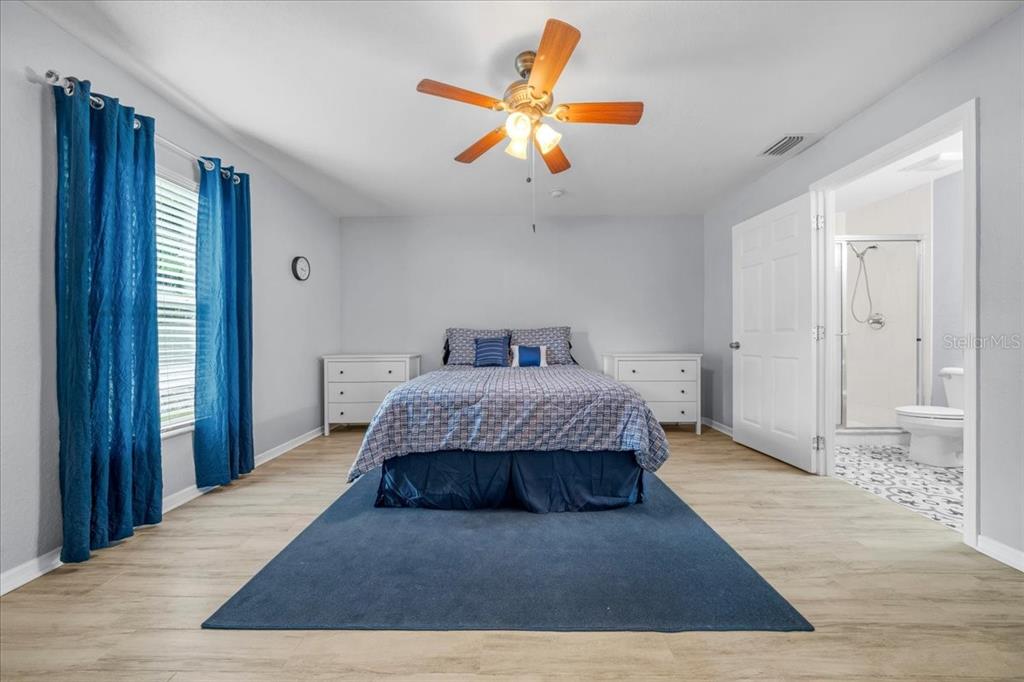 8890 Southwest 33rd Court Ocala, FL 34476 - Photo 16 of 58 a spacious bedroom with a bed and ceiling fan
