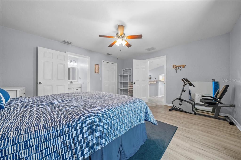 8890 Southwest 33rd Court Ocala, FL 34476 - Photo 17 of 58 a bedroom with a bed and a chandelier