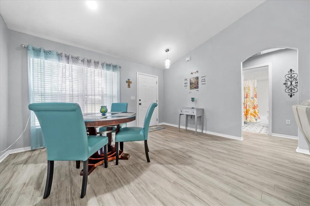 8890 Southwest 33rd Court Ocala, FL 34476 - Photo 3 of 58 a view of a dining room with furniture and wooden floor