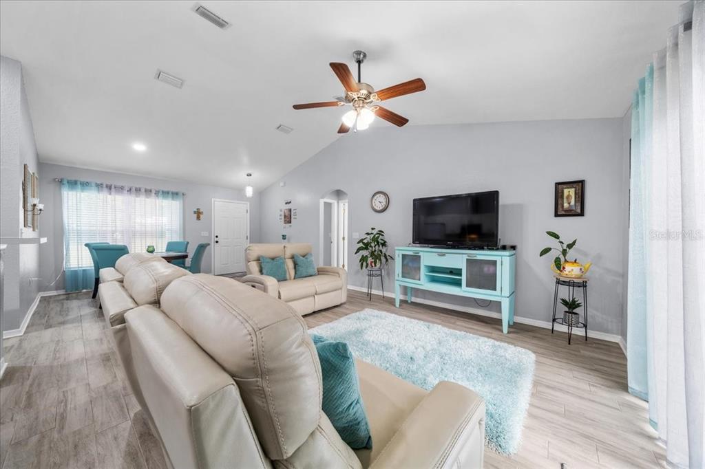 8890 Southwest 33rd Court Ocala, FL 34476 - Photo 7 of 58 a living room with furniture and a flat screen tv