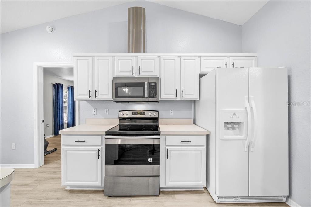8890 Southwest 33rd Court Ocala, FL 34476 - Photo 9 of 58 a kitchen with white cabinets and white appliances