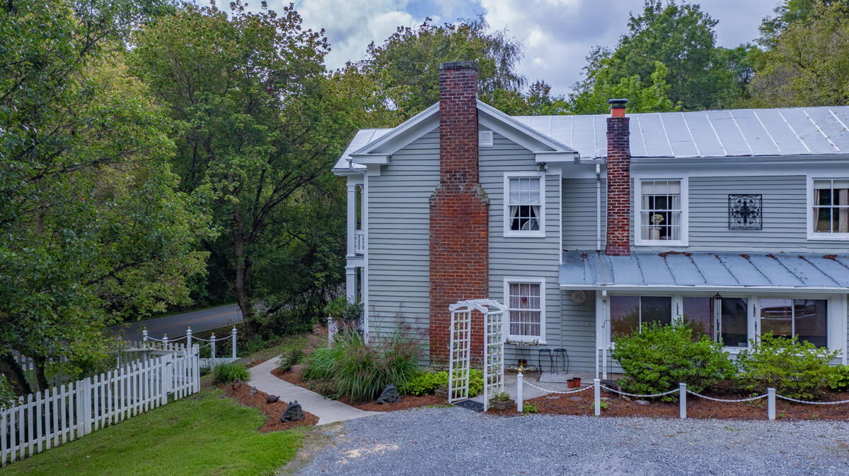492 Greenhouse Road Lexington, VA 24450 - Photo 3 of 27 a view of a house with brick walls and a yard with plants and large trees