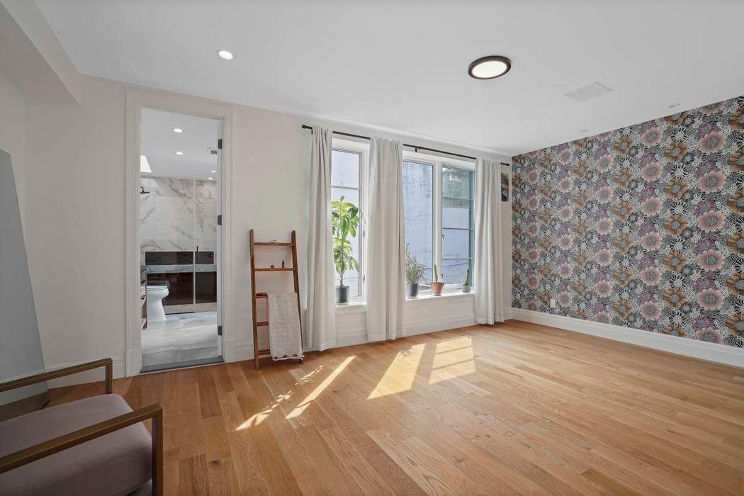 682 Madison Street Brooklyn, NY 11221 - Photo 10 of 28 a view of empty room with wooden floor and fan