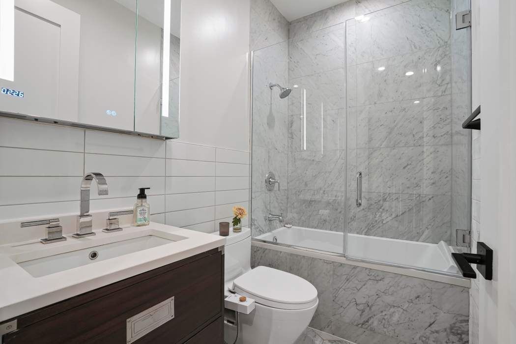 682 Madison Street Brooklyn, NY 11221 - Photo 12 of 28 a bathroom with a sink a toilet and shower