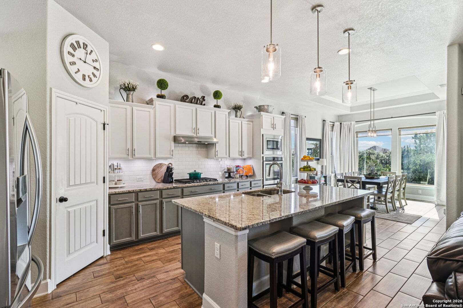 1074 Boulder New Braunfels, TX 78132 - Photo 12 of 40 a kitchen with stainless steel appliances granite countertop a table chairs and a refrigerator