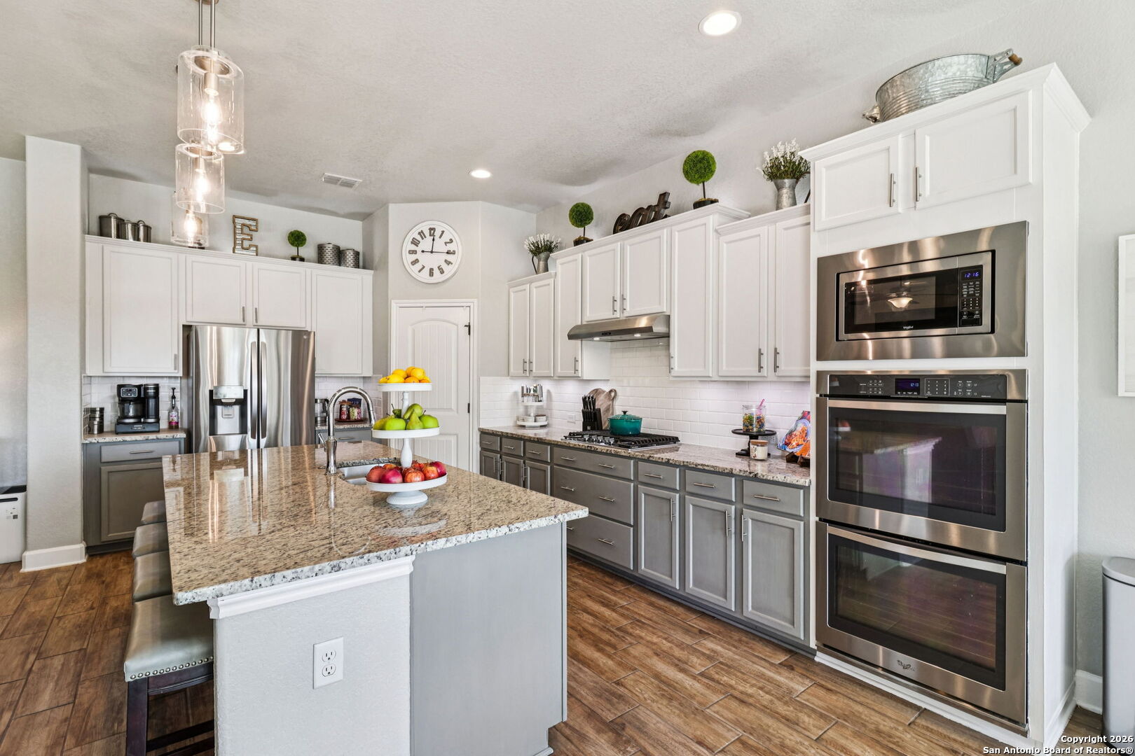 1074 Boulder New Braunfels, TX 78132 - Photo 13 of 40 a kitchen with stainless steel appliances granite countertop a refrigerator a stove top oven a sink dishwasher and white cabinets with wooden floor